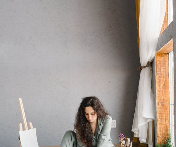Person meditating peacefully by a window at sunrise.